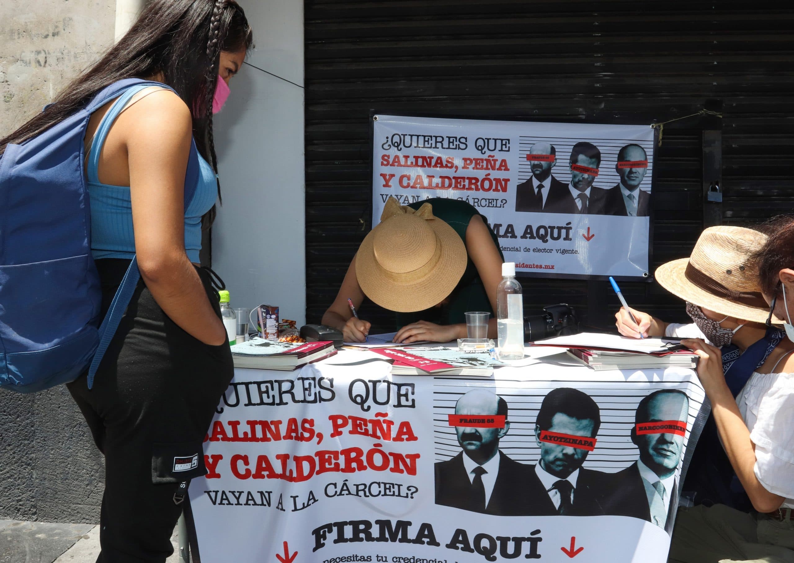 En calles del centro de la CDMX, una mexicana firma la propuesta para enjuiciar a los expresidentes. Foto: EFE
